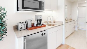 Una cocina moderna equipada con microondas, tostadora, cafetera y lavavajillas.