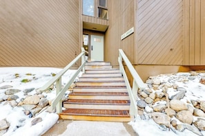 Eine Treppe führt zu einem Gebäudeeingang, an dem ein Schild 'BLUE GROUSE' hängt.