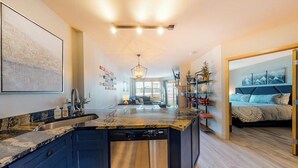 A modern kitchen with a central island, built-in appliances, and a dining area with a view.