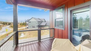 Un balcón con vista a casas y una señal de parada.