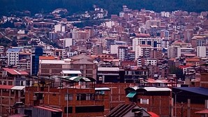 Un paisaje urbano con una cadena montañosa al fondo.