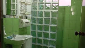 A bathroom with a toilet, sink, and a window with a view.