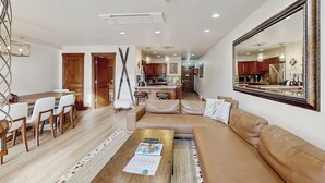 A modern living room with a sofa, coffee table, and dining area. - Winter Condo in Ski-In/Ski-Out Complex w/gondola view, shared pool, hot tub, W/D (Vail)