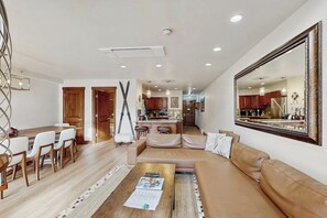 A modern living room with a sofa, coffee table, and dining area. - Winter Condo in Ski-In/Ski-Out Complex w/gondola view, shared pool, hot tub, W/D (Vail)