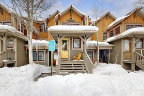 Eine Lodge mit überdachter Eingangspartei, einer barrierefreien Rampe und einer schneebedeckten Fassade.