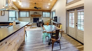 A spacious kitchen with a central island, a fireplace, and a dining area with chairs. - Two-level home on one acre w/ mountain views and deck on Crystal River (Carbondale)
