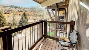 Un balcon en bois offrant une vue sur un paysage montagneux.