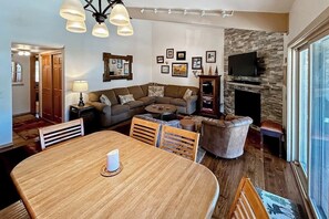 Ein Wohnzimmer mit Kamin, Esstisch und einer Couch.