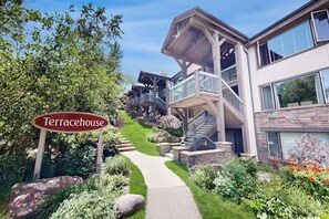 Ein modernes Hotel mit Terrassenhaus-Schild, Steinwegen und üppiger Bepflanzung.