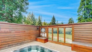 Een hottubgedeelte met houten wanden en uitzicht op bomen.