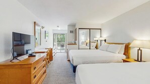 A hotel room with two beds, a desk with a TV, a dresser, and a balcony with a view. - Main Street room - hot tub & pool - walk to lifts, dog-friendly, balcony (Aspen)