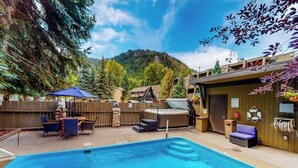 A swimming pool with lounge chairs, a hot tub, and a wooden deck. - Main Street stay - pool & hot tub - walk to lifts, dog-friendly, ground-floor (Aspen)
