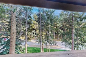 Blick aus einem Fenster auf eine bewaldete Landschaft mit einer Straße im Hintergrund.