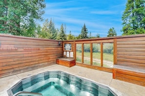 Ein Whirlpoolbereich mit Holzwänden und Blick auf Bäume.