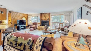 A cozy living room with a fireplace, comfortable seating, and a television. - Condo with fireplace, ski locker, hot tubs, grills, pool, & gym (Breckenridge)