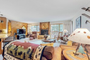 A cozy living room with a fireplace, comfortable seating, and a television. - Condo with fireplace, ski locker, hot tubs, grills, pool, & gym (Breckenridge)