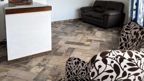 Un área de recepción con un mostrador, un cuadro enmarcado, un sofá y una silla estampada.