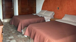 Un dormitorio con dos camas, un armario y suelo de baldosas.