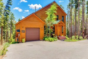 Eine Holzhütte mit Garage, umgeben von Bäumen.
