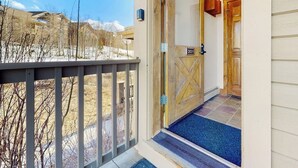 A hotel entrance with a wooden door, a number sign, and a blue carpet. - Ski-in/out condo with amazing views, washer/dryer, fireplace, & hot tub (Granby)