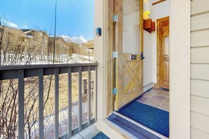 A hotel entrance with a wooden door, a number sign, and a blue carpet. - Ski-in/out condo with amazing views, washer/dryer, fireplace, & hot tub (Granby)