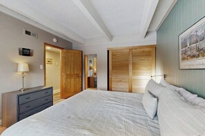A bedroom with a bed, dresser, wardrobe, and a framed picture on the wall. - Shuttle to lifts from condo w/ panoramic views (Breckenridge)