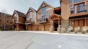 A multi-story building with a central entrance, large windows, and balconies. - Townhouse with a ski lodge feel with mountain view, W/D, fireplace & balcony (Keystone)