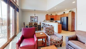 A spacious living area with a red chair, patterned sofa, and a dining table. - Townhouse with a ski lodge feel with mountain view, W/D, fireplace & balcony (Keystone)