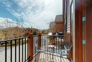 A balcony with a metal railing, two chairs, and a small table. - Townhouse with a ski lodge feel with mountain view, W/D, fireplace & balcony (Keystone)