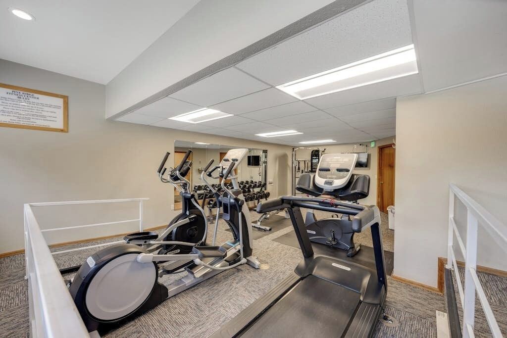 A gym with treadmills, elliptical machines, and weight machines.