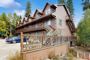 Ein mehrstöckiges Holzgebäude mit Balkonen und einem Schild mit der Aufschrift 'The Rapids Condominiums'.