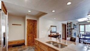 Una cocina con encimeras de granito, armarios de madera, horno integrado y salpicadero de piedra.