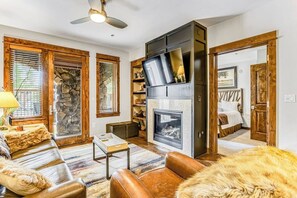 Ein gemütliches Wohnzimmer mit Kamin, Ledermöbeln und Holzelementen.