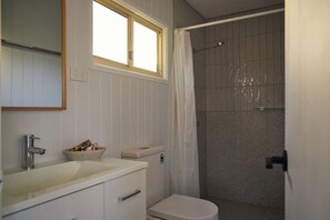A bathroom with a sink, toilet, and shower area. - The Mook Mollymook - Clyde 13B Cabin (Mollymook)