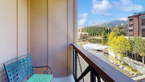 Ein Balkon mit Blick auf einen See, Berge und Bäume.