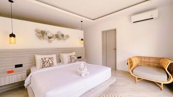 A modern bedroom with a large bed, bedside tables, a wicker sofa, and a wall-mounted air conditioner.