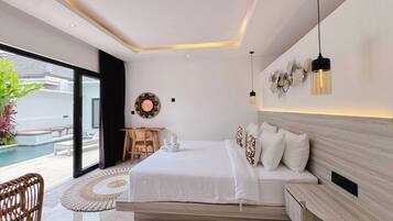 A modern bedroom with a large bed, a desk, and a view of a swimming pool.