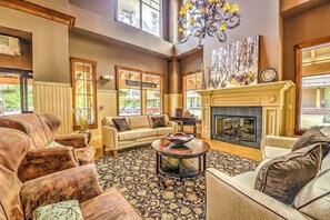 A spacious living room with leather sofas, a fireplace, and a view of the outside. - Walk-to-lift condo with gas fireplace, hot tubs, pool, gym & steam room (Breckenridge)