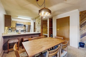 A kitchen with wooden cabinets, a microwave, and a refrigerator. - Spacious, in-town condo with balcony, pools, hot tub, tennis - walk to lifts (Breckenridge)