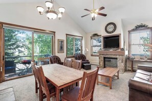 A spacious living area with a fireplace, dining table, and comfortable seating. - Main Street condo with mountain view, fireplace, pool & hot tubs - walk to lifts (Breckenridge)