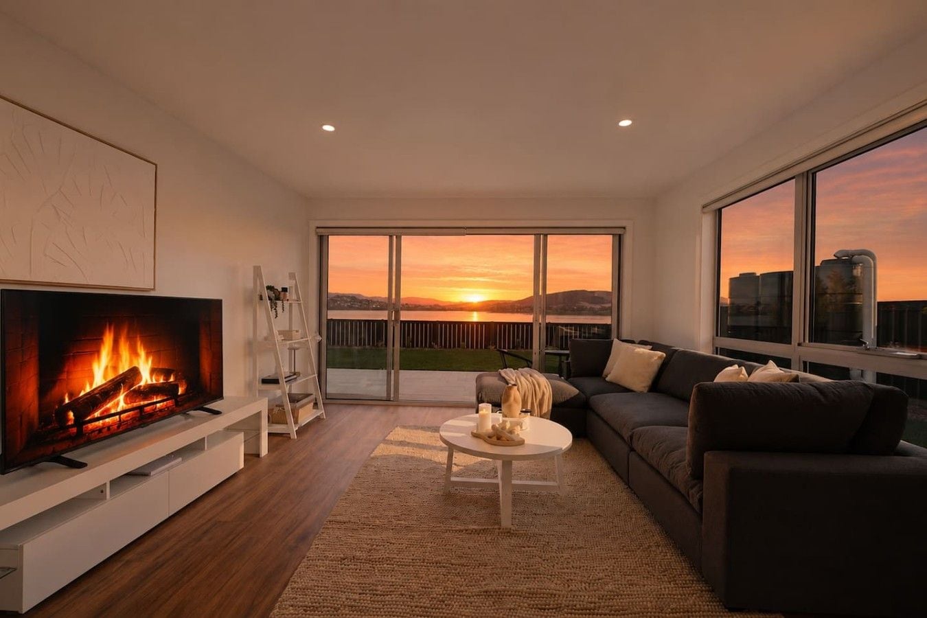 A modern living room with a fireplace, a sofa, a coffee table, and a television.