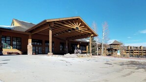 A building with a covered entrance, large windows, and a stone pillar. - 3rd-floor retreat with balconies, in/outdoor pools, game room, gym, views (Granby)