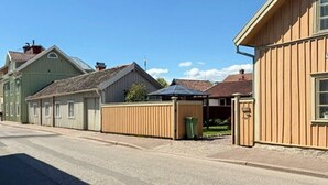 Et gadesyn med en række træhuse, en klar himmel og en belagt vej.