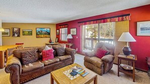 Ein Wohnzimmer mit braunem Ledersofa, einem Holztisch und einer Wand in Rot.