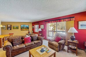 Ein Wohnzimmer mit braunem Ledersofa, einem Holztisch und einer Wand in Rot.