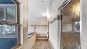 A narrow bathroom with a wooden floor, a sink, and a glass shower enclosure. - Skiers studio with WiFi, pool, hot tub, sauna, & balcony in downtown location (Breckenridge)