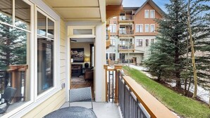 Un edificio residencial con balcón, ventanas grandes y vistas a casas vecinas.