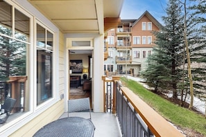 A residential building with a balcony, large windows, and a view of neighboring houses. - Modern mountain condo with balcony, pool & hot tubs, walk to lifts/downtown (Breckenridge)