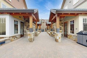 A corridor with stone pillars, wooden beams, and a clear sky. - Beautiful condo with walk-to-lift location, hot tubs, pool, gym & theater (Breckenridge)