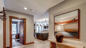 Una cocina moderna con armarios oscuros, una isla central e iluminación colgante.